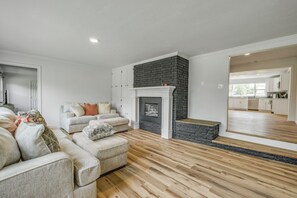 Ein modernes Wohnzimmer mit Kamin, einer Sofagarnitur und Holzboden.