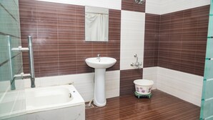 Un baño con un lavamanos blanco, un inodoro pequeño y una bañera.