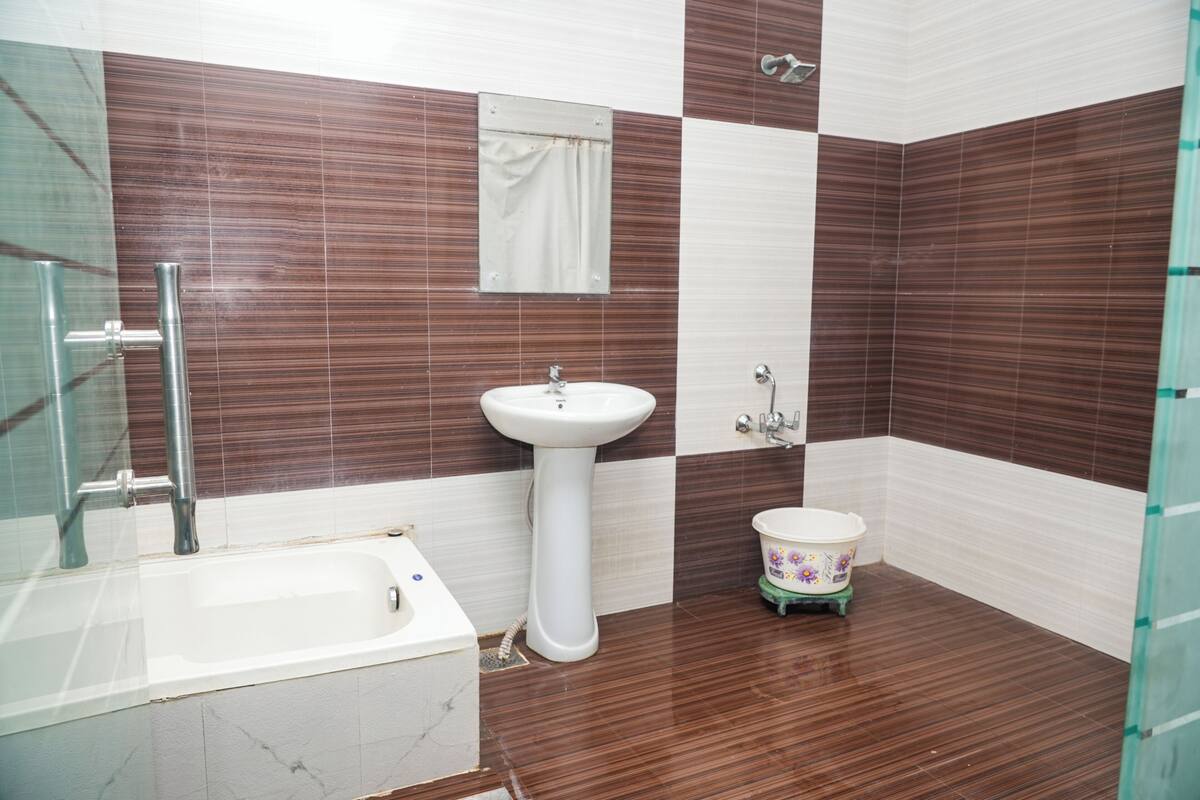 Un baño con un lavamanos blanco, un inodoro pequeño y una bañera.