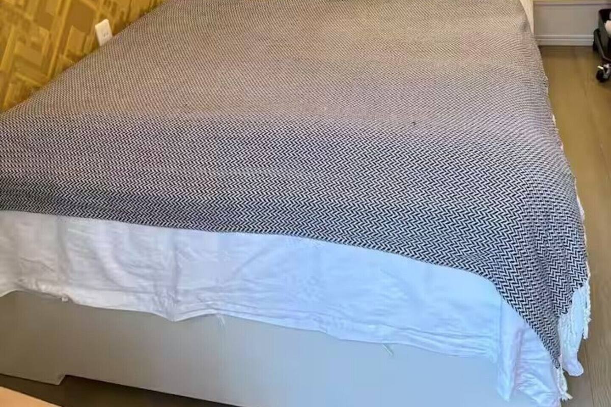 Quarto de hotel com cama, mesa de cabeceira, sanita e zona de duche.