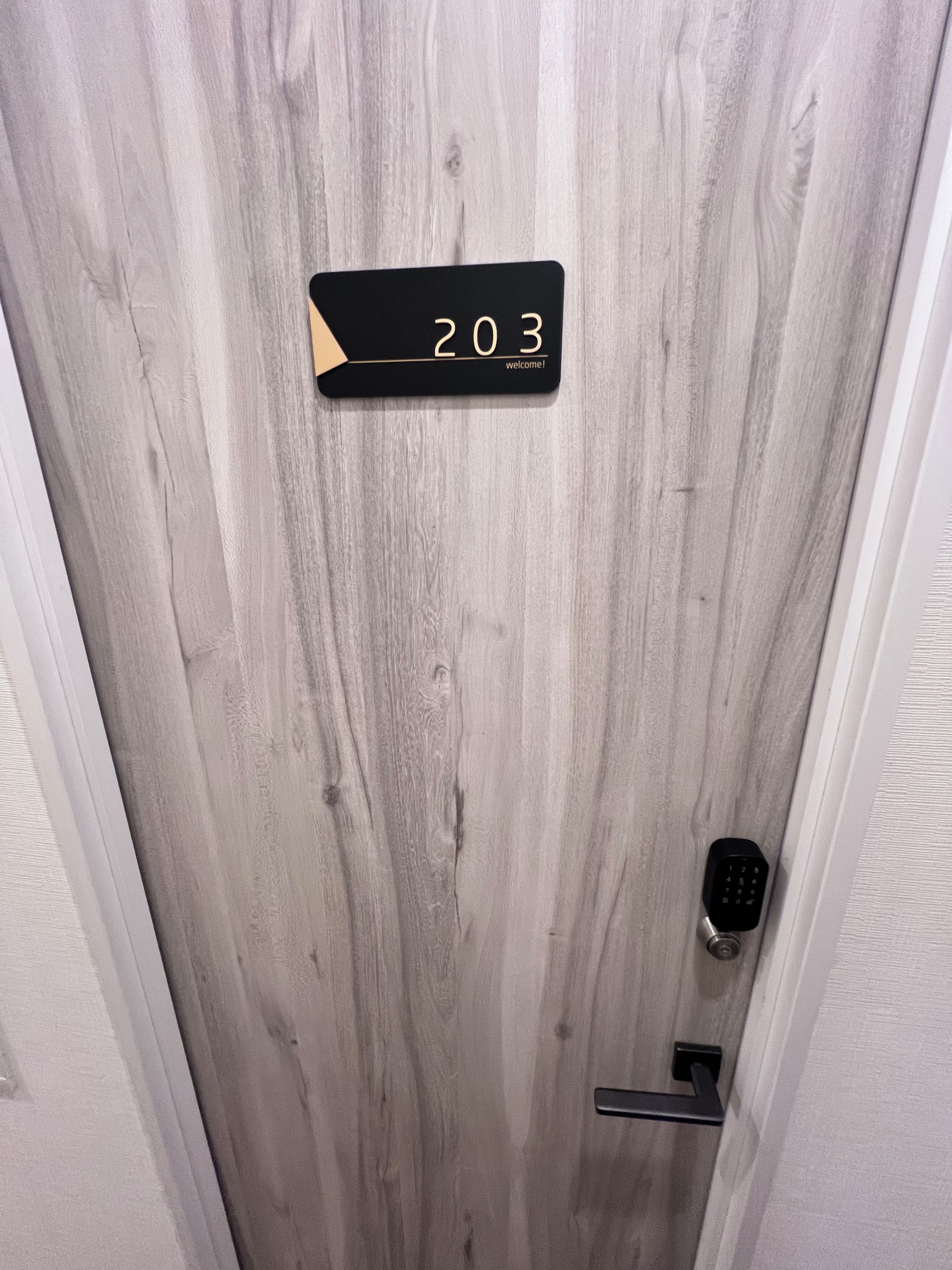 A door with a number sign '203' and a keypad lock.
