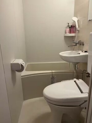 Un baño pequeño con inodoro, lavabo y bañera.
