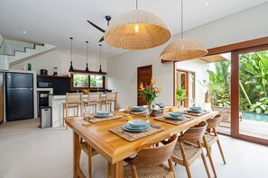 A modern kitchen with a refrigerator, oven, and coffee maker. - High End Luxury 3BR Villa Walking Distance to Nuanu City (Tabanan)