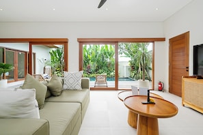 A modern living room with a sofa, coffee table, and a television. - High End Luxury 3BR Villa Walking Distance to Nuanu City (Tabanan)