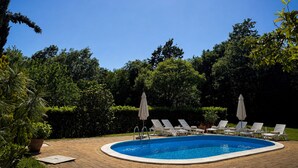 A swimming pool with lounge chairs and umbrellas, surrounded by greenery. - Marisa Olive Grove - App Terra, Labin, Croatia (Labin)