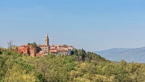 A historic town with a prominent church and tower on a hill, surrounded by greenery. - Marisa Olive Grove - App Terra, Labin, Croatia (Labin)