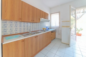 Eine Küche mit Holzausstattung, einer Spüle, einem Herd und einem Kühlschrank.