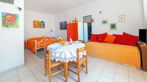 A bedroom with a bed, a table with chairs, a wardrobe, and a mirror. - Leuca Relax & Sea n.1b, Castrignano del Capo, Italy (Castrignano del Capo)