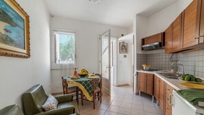 Eine Küche mit Holzausstattung, einem Esstisch mit Stühlen und einem Bild an der Wand.