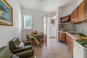 Eine Küche mit Holzausstattung, einem Esstisch mit Stühlen und einem Bild an der Wand.