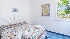 Una camera da letto con un letto, una finestra e un condizionatore d'aria a parete.
