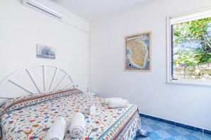 A bedroom with a bed, a window, and a wall-mounted air conditioner. - Leuca Relax&Sea n.3bbis, Castrignano del Capo, Italy (Castrignano del Capo)