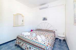 A bedroom with a bed, a small bedside table, a chair, a mirror, and an air conditioning unit. - Leuca Relax&Sea n.3bbis, Castrignano del Capo, Italy (Castrignano del Capo)