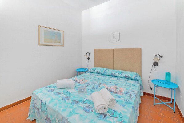 A room with a bed, a small table, a wall-mounted lamp, and a framed picture. - Leuca Relax&Sea n.3b, Castrignano del Capo, Italy (Castrignano del Capo)