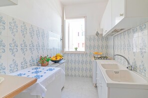 A narrow kitchen with white cabinets, a sink, and a window. - Leuca Relax&Sea n.3b, Castrignano del Capo, Italy (Castrignano del Capo)