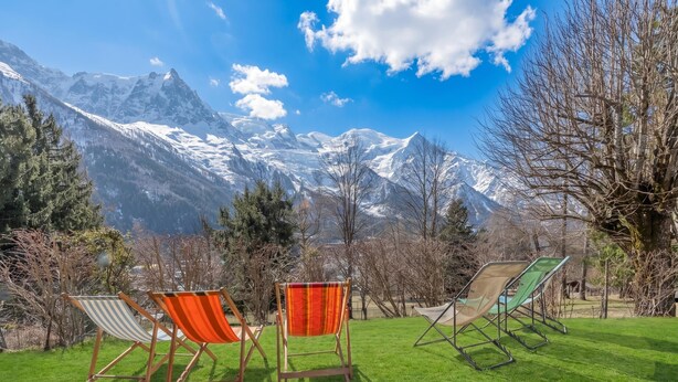 A grassy area with four lounge chairs facing a mountain backdrop. - Chalet Les Airelles Mont-Blanc View, Chamonix, France (Chamonix)