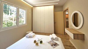 A modern bedroom with a large bed, a vanity with a mirror, and a walk-in closet. - Ionian Escape 038, Vlore, Albania (Vlore)