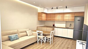 A modern kitchen with wooden cabinets, a built-in oven, and a refrigerator. - Ionian Escape 038, Vlore, Albania (Vlore)