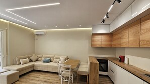 A modern kitchen with wooden cabinets, a dining area with a table and chairs, and a built-in oven. - Ionian Escape 038, Vlore, Albania (Vlore)