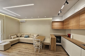 Eine moderne Küche mit Holzausbau, einem Essbereich mit Tisch und Stühlen sowie einem eingebauten Ofen.