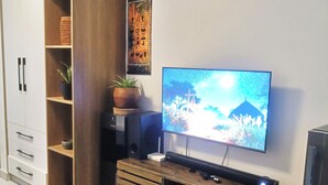 Un saló amb televisió, un moble de fusta i una taula de centre.