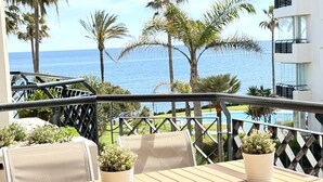 A balcony with a view of the sea, wooden furniture, and potted plants. - MI CAPRICHO BEACHFRONT: 210 with sea view (Mijas)