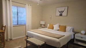 A bedroom with a bed, bedside table, lamp, chair, and a ceiling fan. - Spacious, zen, fully-equipped 3 bed/2 bath home with red rock views (Sedona)