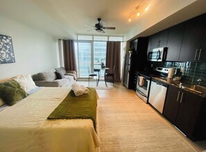 Ein Hotelzimmer mit Bett, einer Couch, einem Esstisch und einer Küchenzeile.