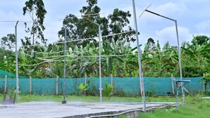 Uma plataforma de concreto com postes de metal e uma cerca de rede verde.