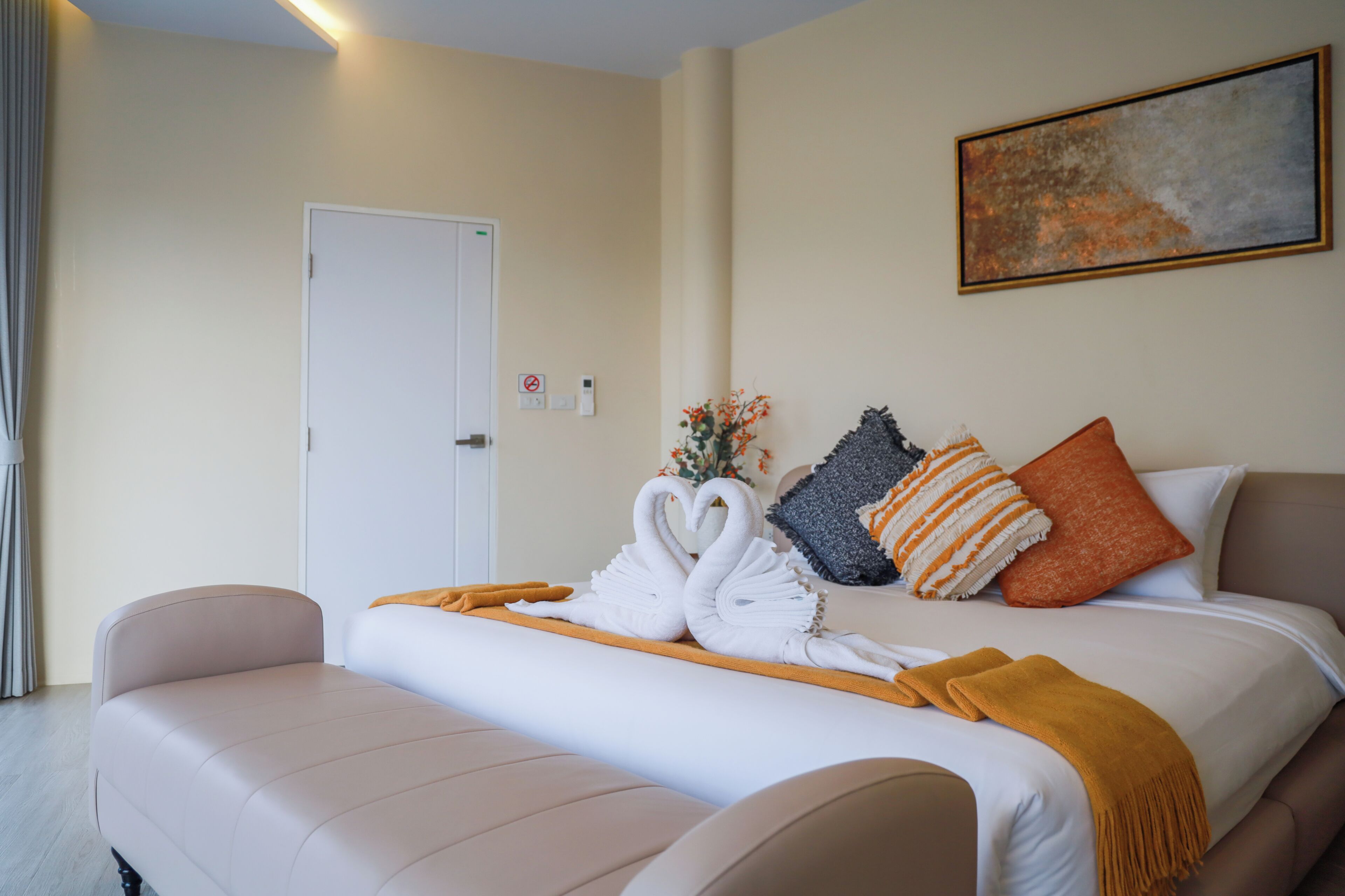 Een hotelkamer met een bed, een bank, een deur en een schilderij aan de muur.