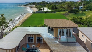 Una propiedad residencial con piscina, zona de patio y vista a la playa y al océano.