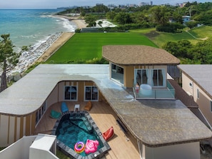 Una propiedad residencial con piscina, zona de patio y vista a la playa y al océano.