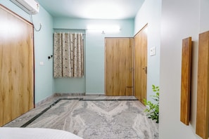 A room with a marble floor, wooden doors, a curtain, and an air conditioning unit.