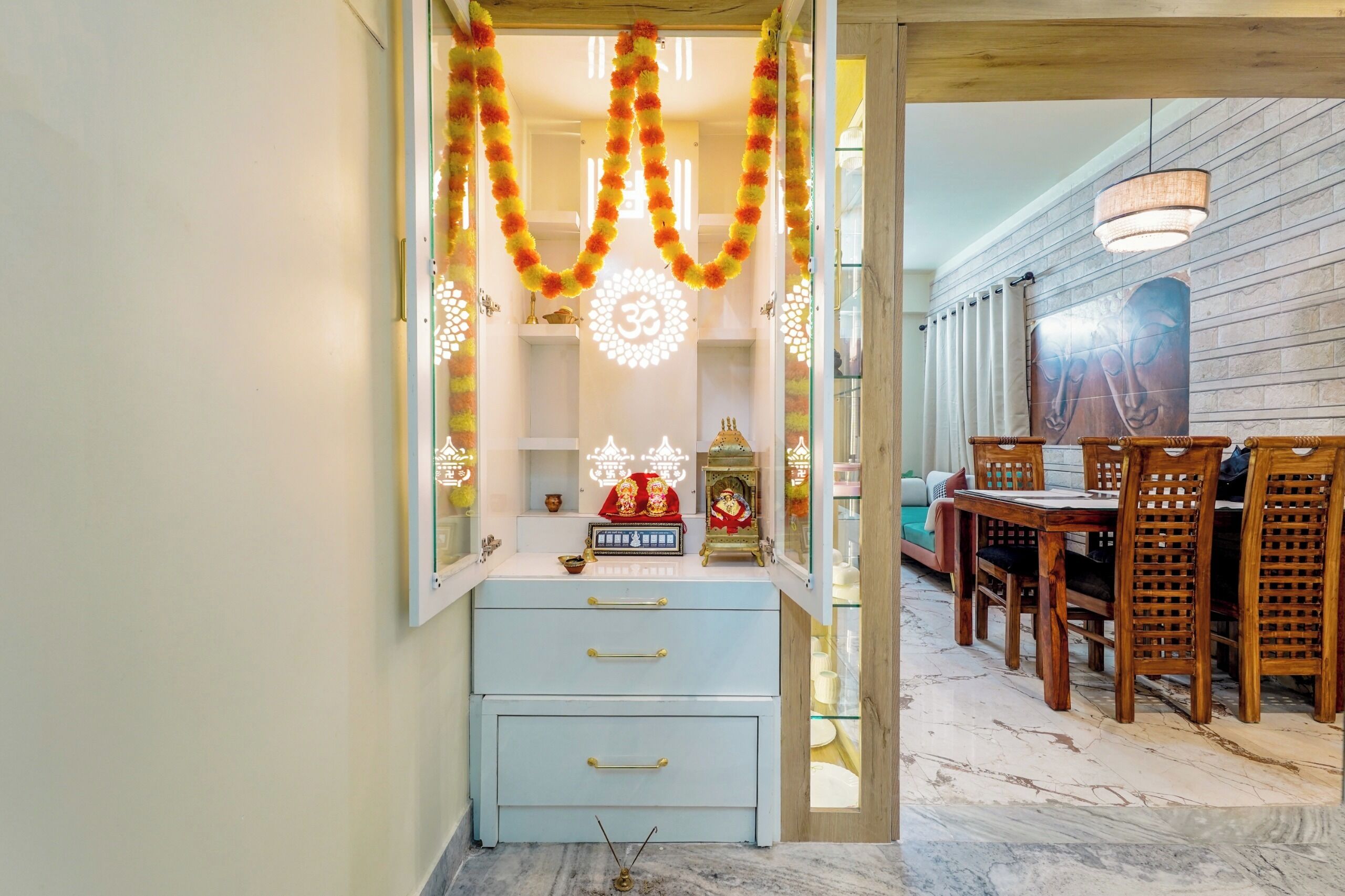 A room with a shrine, a dining area with wooden chairs, and a marble floor.