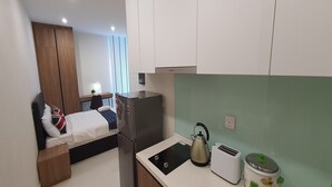A compact kitchenette with a refrigerator, kettle, toaster, and slow cooker. - 90309 Kozi Square (Kuching)