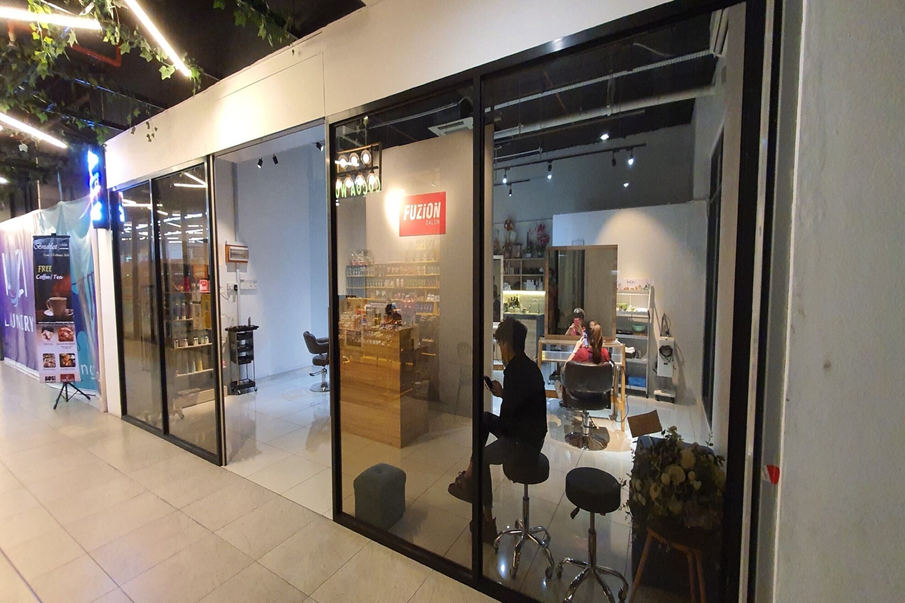 A salon with a glass storefront, a visible sign reading 'FUSION Salon,' and a person sitting inside.
