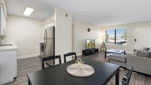 En moderne stue med spisebord, sofa og fjernsyn.