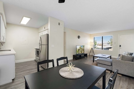 A modern living room with a dining table, sofa, and TV.. 2BR Modern Mesa Stay Near DT with Pools & Gym