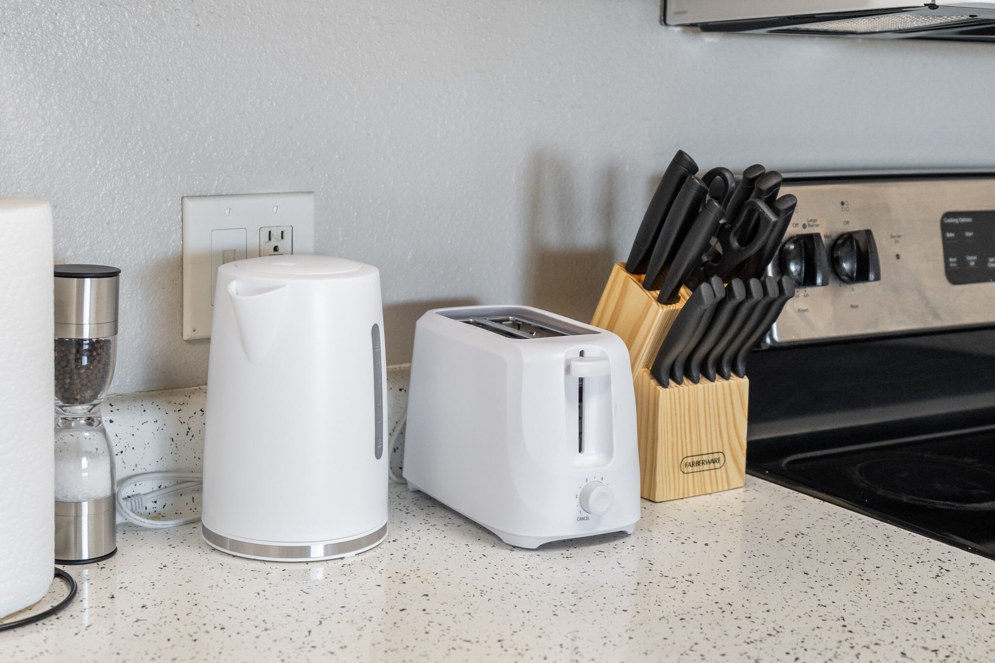 Une cuisine équipée d’un grille-pain, d’une machine à café, d’un bloc à couteaux et d’une cuisinière.