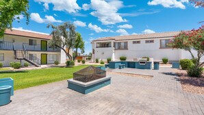 Un patio con piscina, mobiliario exterior y una escalera que lleva a un edificio.