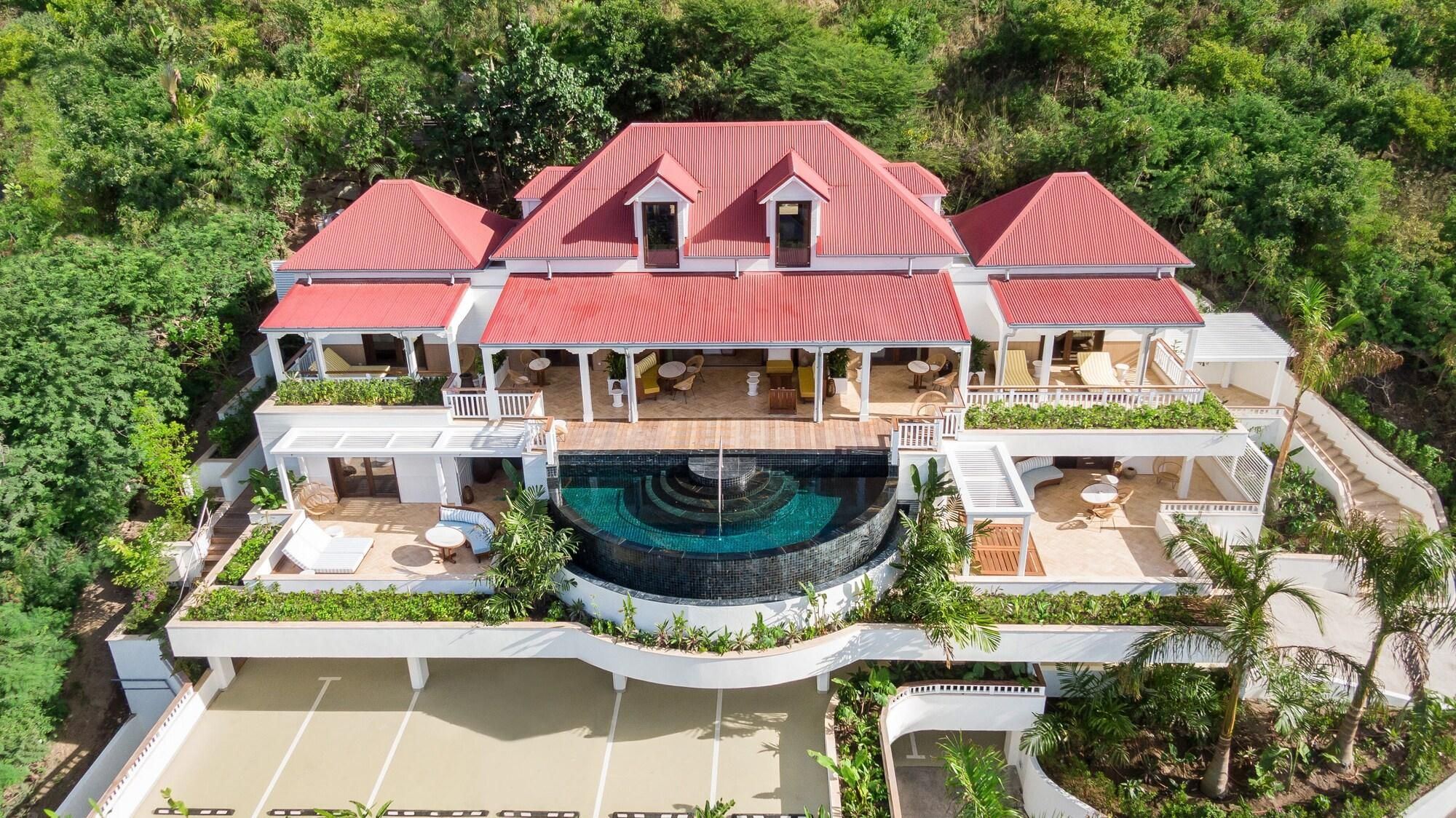 A large, multi-story resort with a central swimming pool, multiple balconies, and outdoor seating areas.