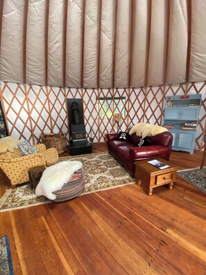 A cozy interior with a sofa, a small table, a rug, and a bookshelf.