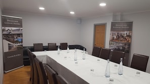 A conference room with a long table, chairs, and informational posters on the walls.