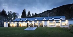 A modern house with a large front porch, multiple windows, and a well-maintained lawn. - The Brander Lodge Hotel And Bistro (Taynuilt)