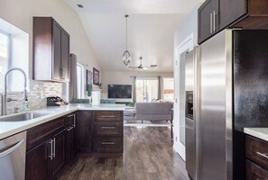 A modern kitchen with dark wood cabinets, stainless steel appliances, and a large island. - Spacious Single Level Home with 2 King Beds Sleeps 8 (Salida)