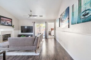 A living room with a sofa, TV, fireplace, and artwork on the walls. - Spacious Single Level Home with 2 King Beds Sleeps 8 (Salida)