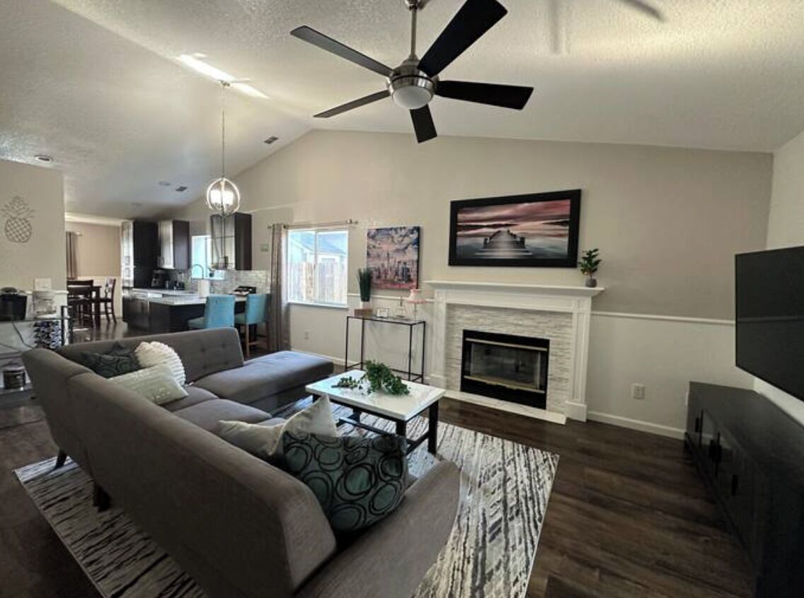 A living room with a sofa, coffee table, fireplace, and a TV.