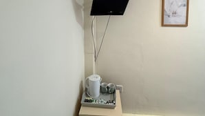 A small room with a desk, a mounted TV, a framed picture on the wall, and a waste bin under the desk. - Chatsworth Hotel (Skegness)