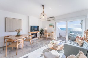 En moderne stue med pejs, spiseområde og en sofa med havudsigt.