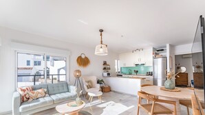 Een moderne woonkamer met een bank, salontafel en eettafel.